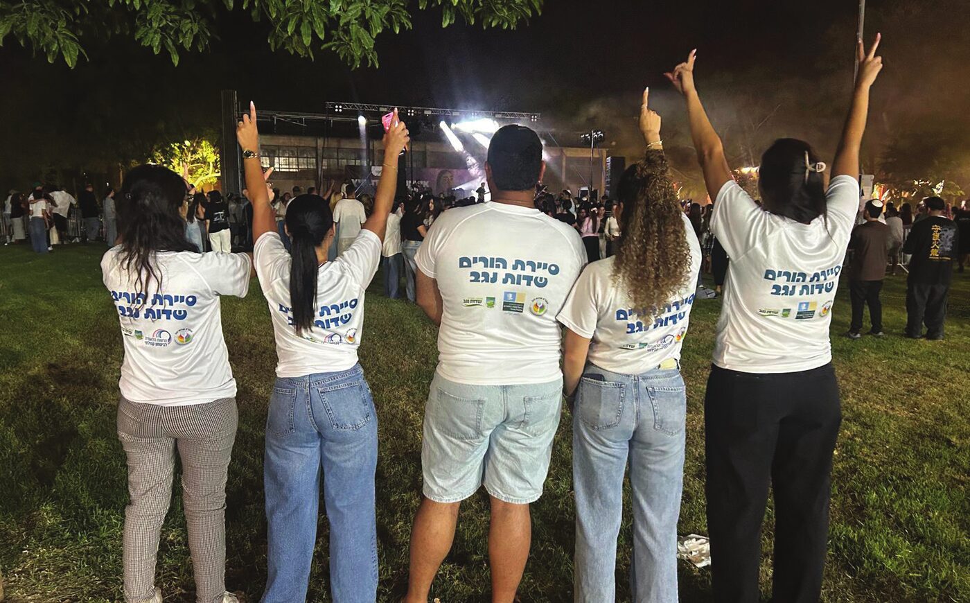 חברי סיירת ההורים של שדות נגב בחולצות לבנות מול במה באירוע לילה